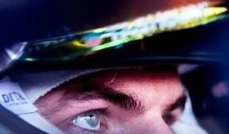 Close-up of a race car driver's eye, highlighting focus and determination, with a helmet reflecting colorful lights.